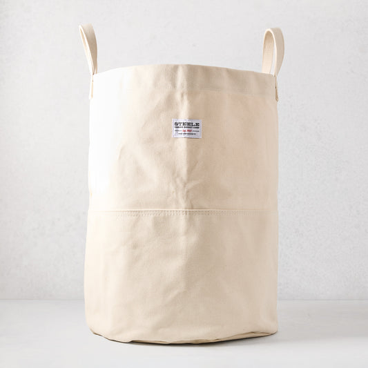 Steele natural-toned canvas storage bin with two handles and a brand label.