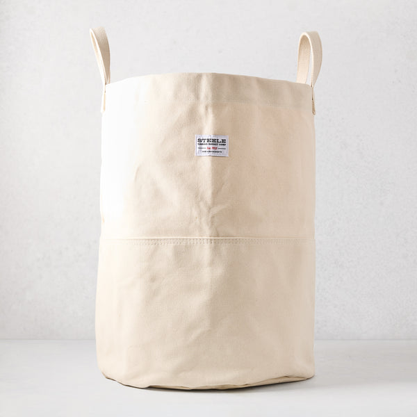 Steele natural-toned canvas storage bin with two handles and a brand label.