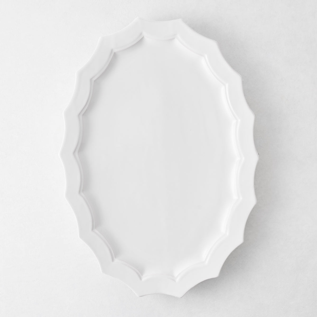 Stella white ceramic oval serving platter with a decorative scalloped edge, 17.3 by 12.8 inches.