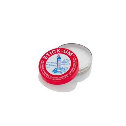 Red and white tin of Stick Um Candle Adhesive, 0.5 oz, with a lit candle graphic.