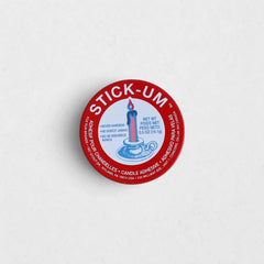 Round red tin of Stick-Um candle wax adhesive with blue text and a candle illustration on a white background.