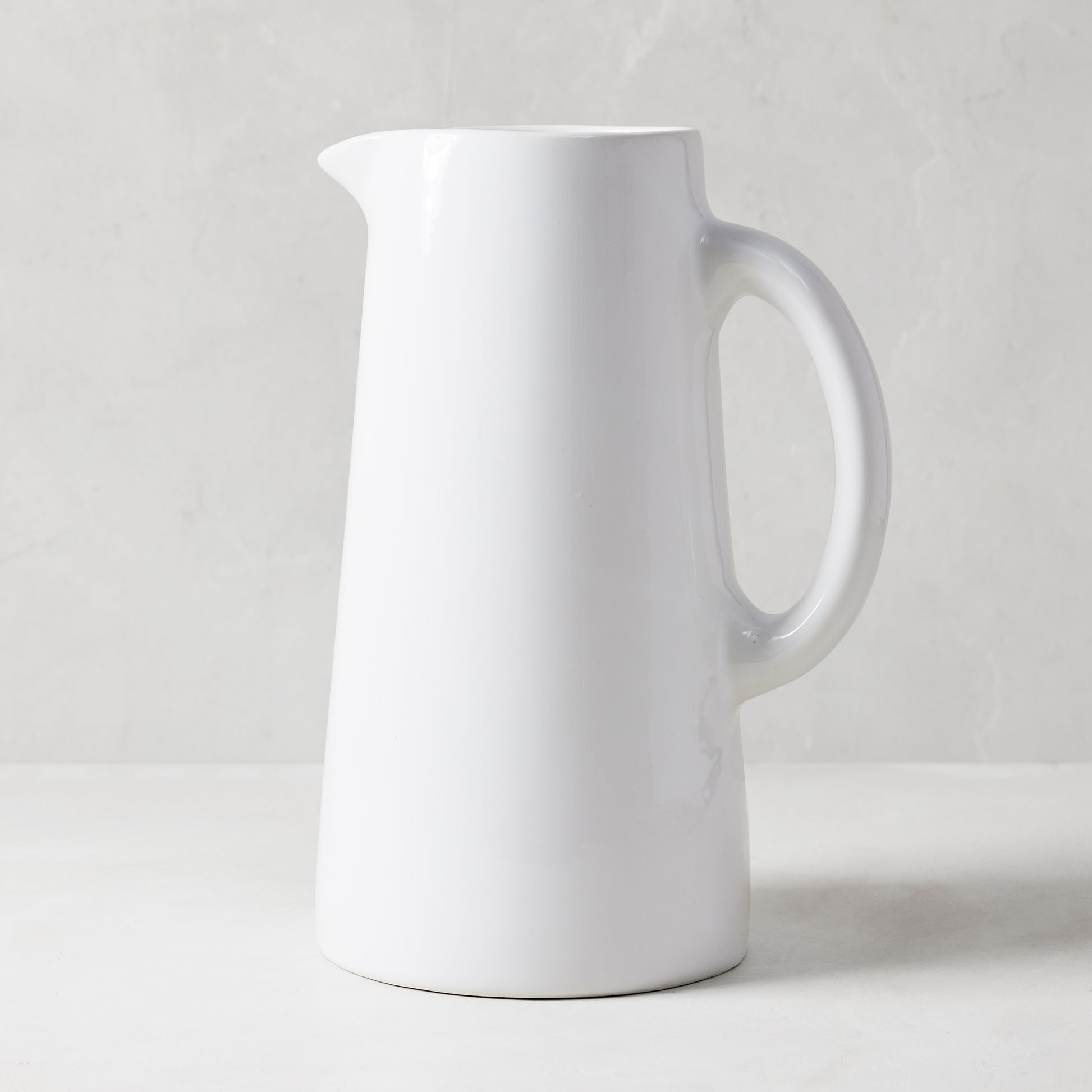 Stinson Large white ceramic pitcher, handmade in Italy, with a large handle and spout.