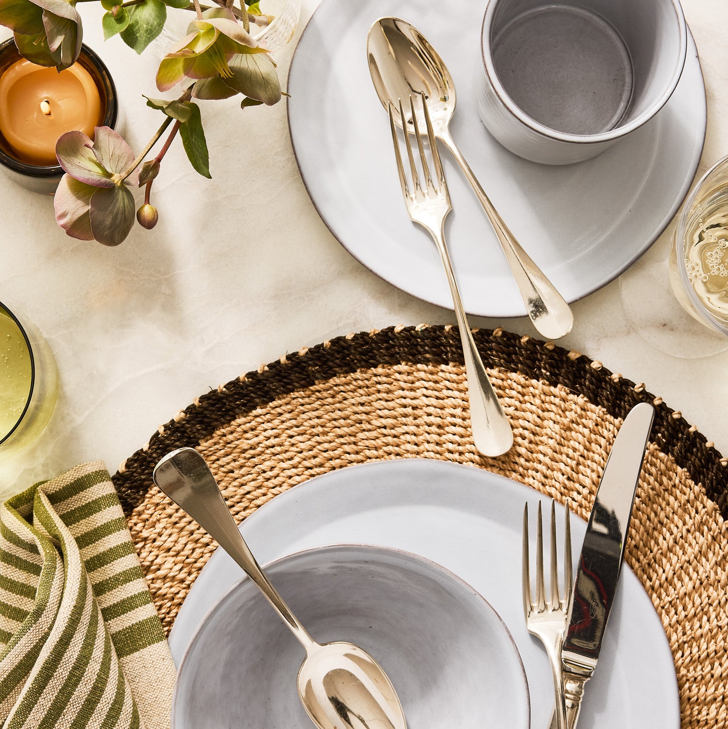 Stone grey terracotta dinner plate, 10.75" diameter, with a matching bowl, silverware, and woven placemat.