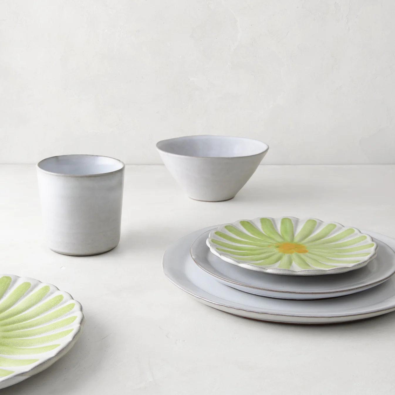 Stone grey terracotta dinner plate with a green and yellow floral accent plate, bowl, and cup.