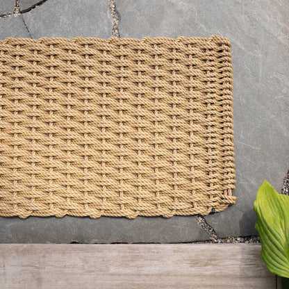 Straw Braided Rope Doormat, handwoven light brown rope with a tight weave, on a gray stone patio.