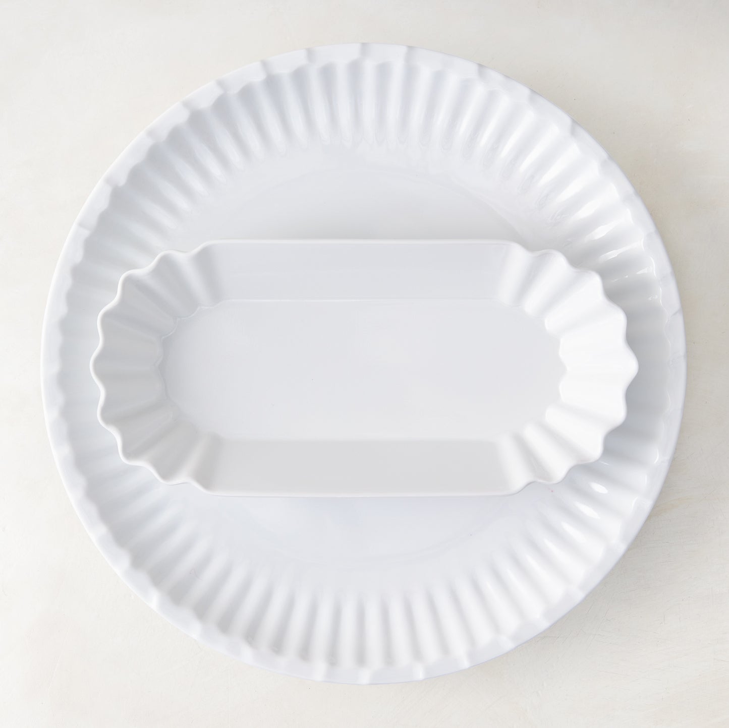 White Melamine Street Eats Hot Dog Holder, 9"L x 4"W, with scalloped edges, on a larger round plate.