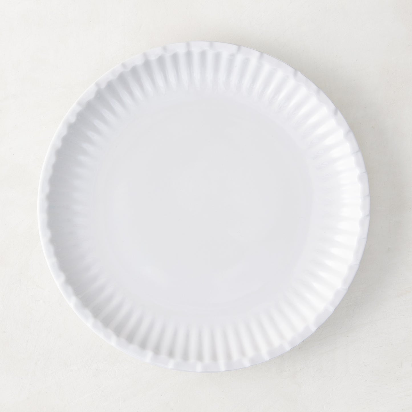 White 8.5" Melamine Street Eats Salad Plate with ribbed edge, mimicking a paper plate.