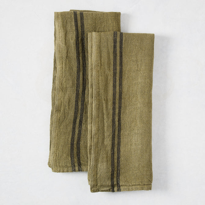 Set of two folded deep green French linen hand towels with black stripes.