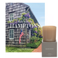 Summer in the Hamptons" gift set: "Walk With Me: Hamptons" book with a shingled house cover and a beige Montauk candle on a gray box.