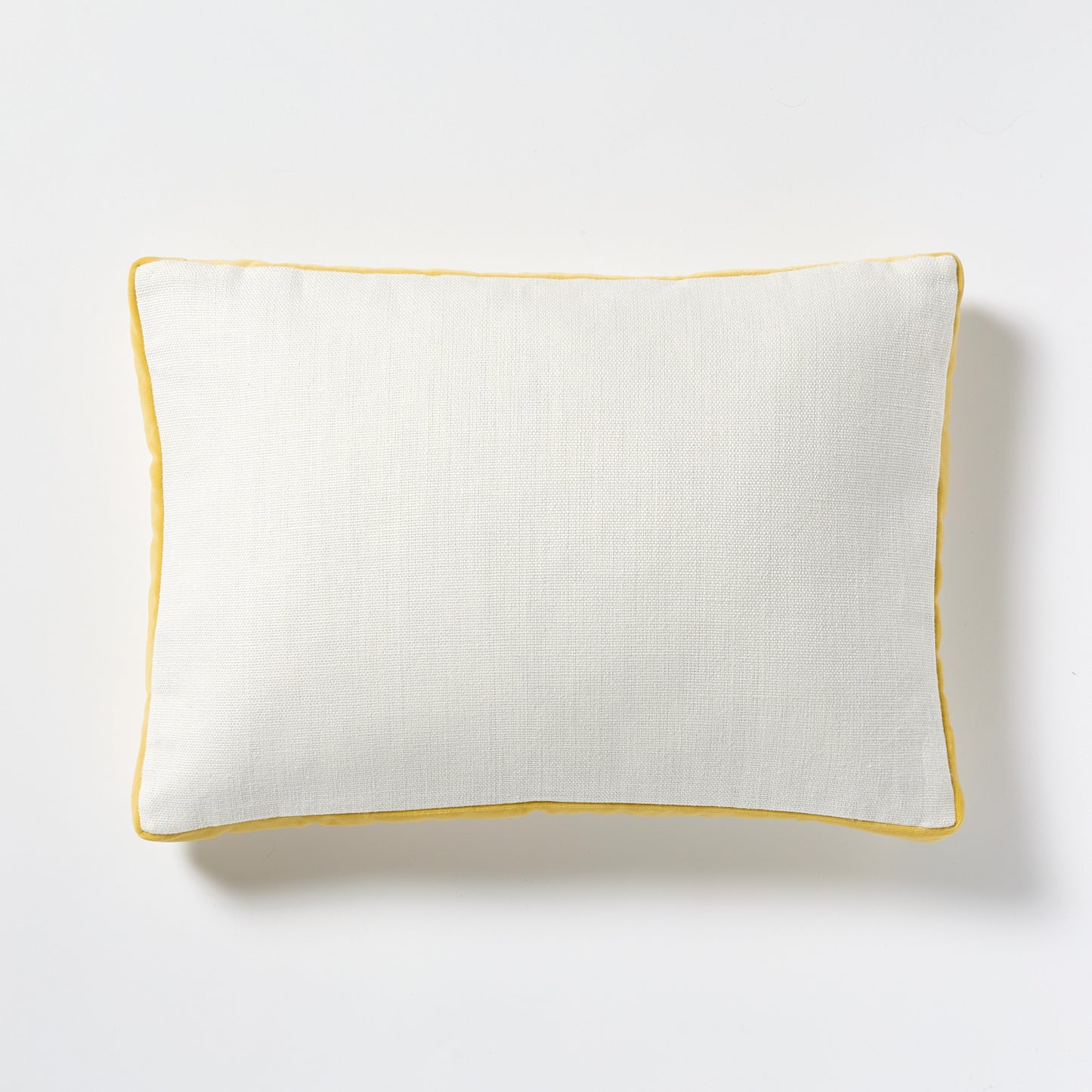 White linen lumbar pillow with sun yellow velvet gusseted trim.