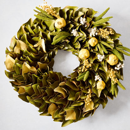 Sunlit Meadow Wreath with green magnolia leaves, chartreuse yellow pomegranates, and yarrow sprigs.