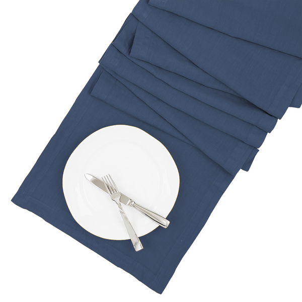 Surf HG hand-dyed linen table runner in deep blue, 18"x108", with a white plate and silverware.
