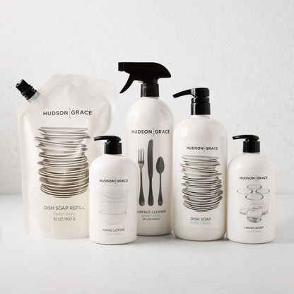 Hudson Grace Sweet Basil Dish Soap Refill pouch and four white bottles with black pumps/sprayer.