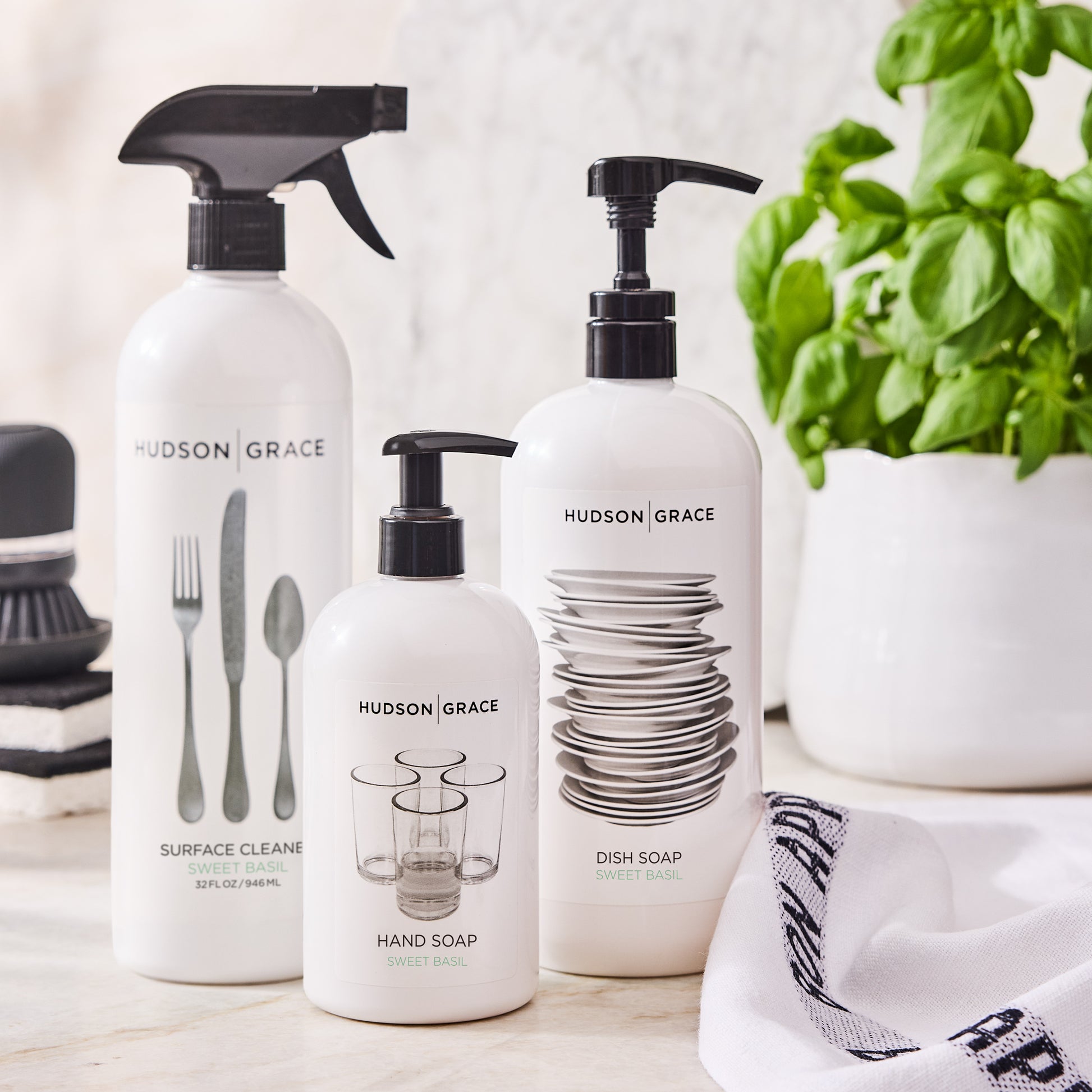 Hudson Grace Sweet Basil Surface Cleaner, Hand Soap, and Dish Soap in white bottles with black pumps.