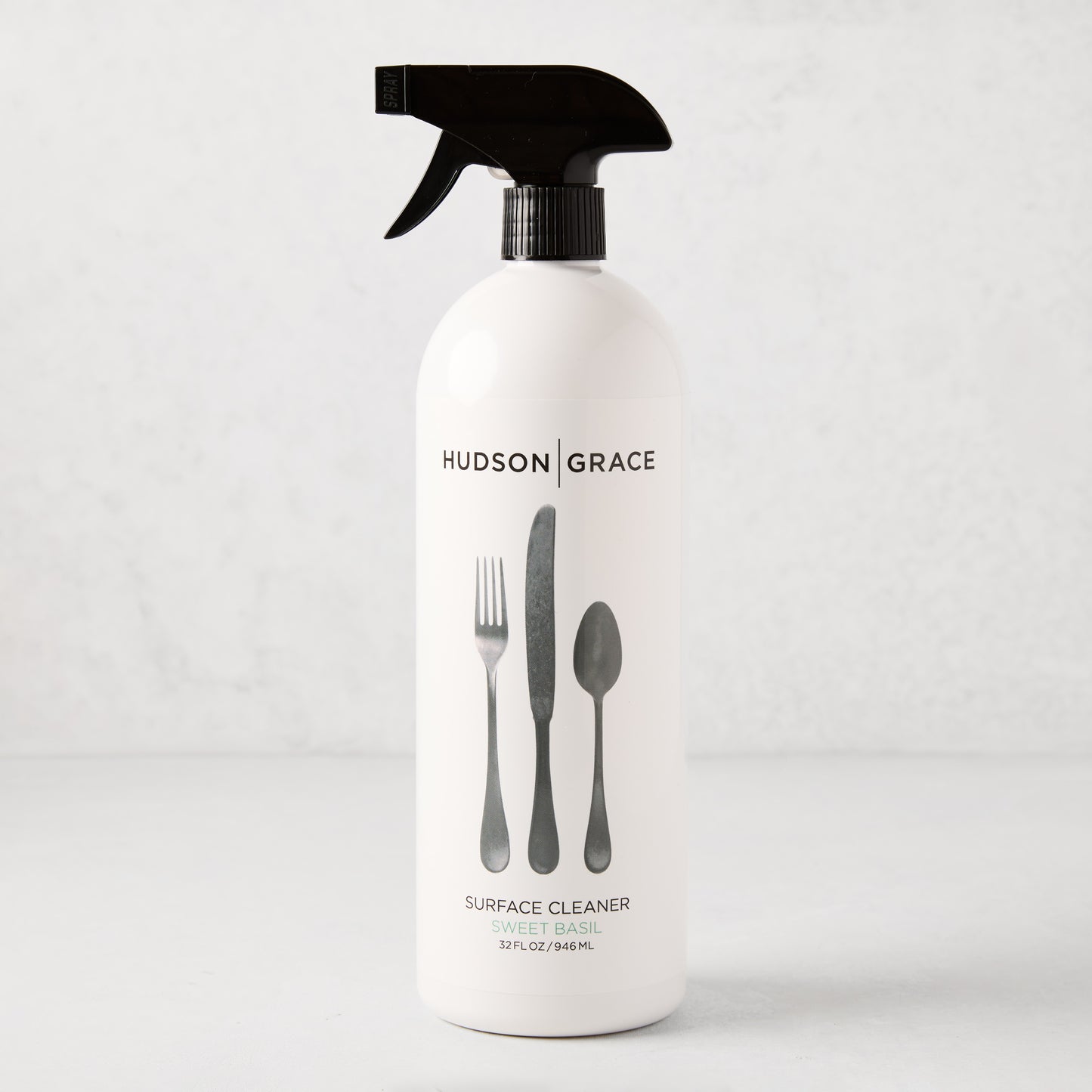 HG Sweet Basil Surface Cleaner, 32oz white spray bottle with black top and cutlery graphic.