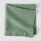 Swiss Chard HG Signature hand-dyed sage green linen napkin, folded, with visible texture and mitered corners.