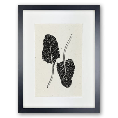 Black framed Swiss Chard handmade paper wall art print, featuring two dark leaves on light textured paper.