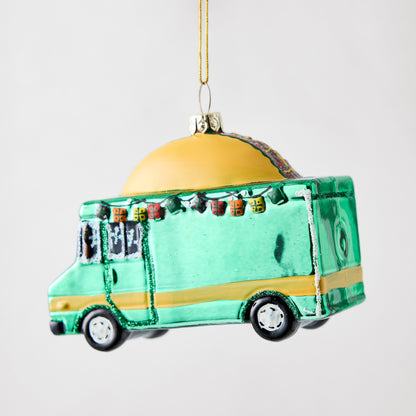 Hand-painted glass taco truck Christmas ornament in green and yellow with glitter accents and string hanger.