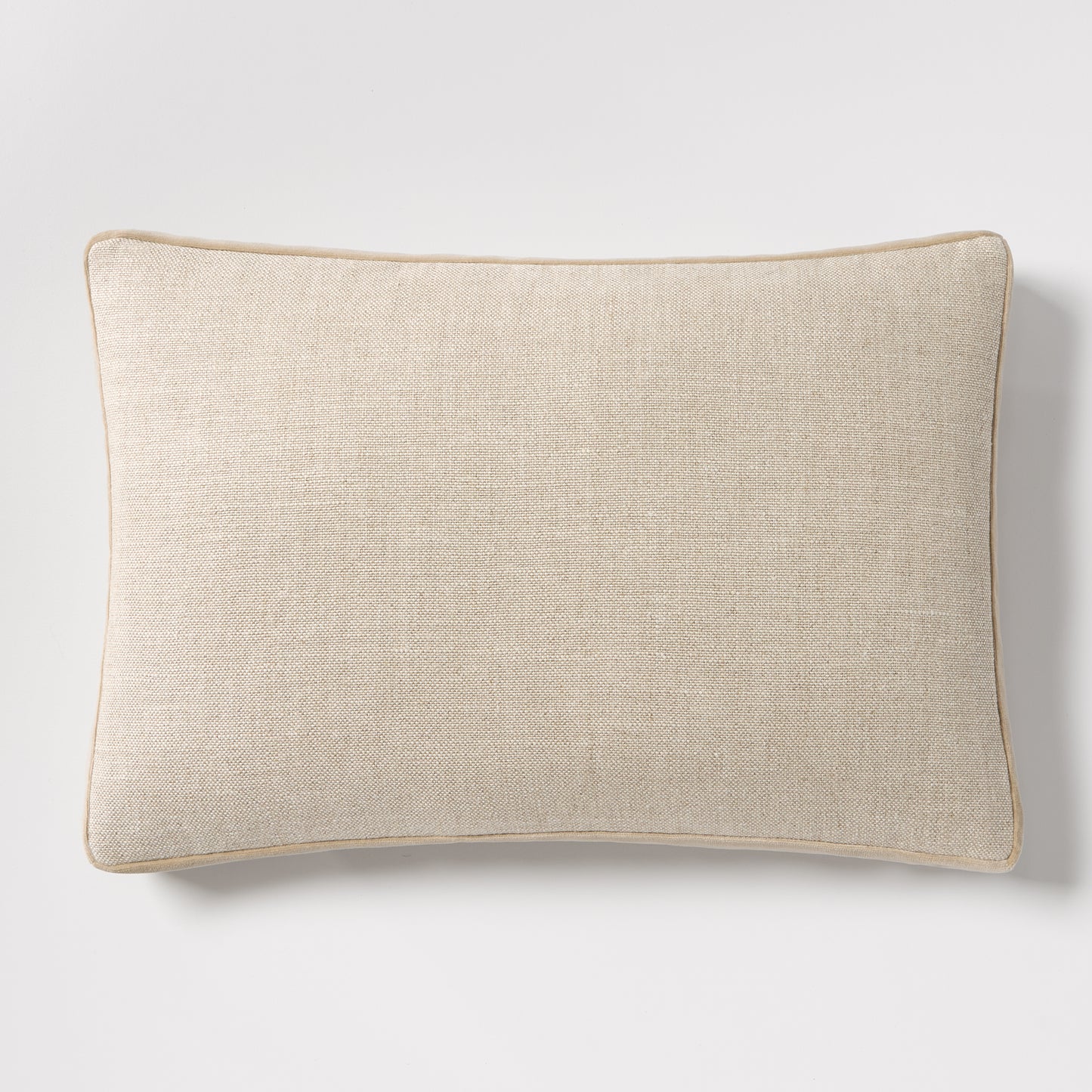 Tan velvet gusseted and linen lumbar pillow, 20"L x 14"H, with piped edges.