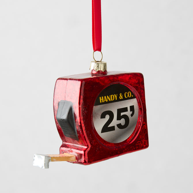 Red glitter glass tape measure Christmas ornament with "HANDY & CO. 25'" label.
