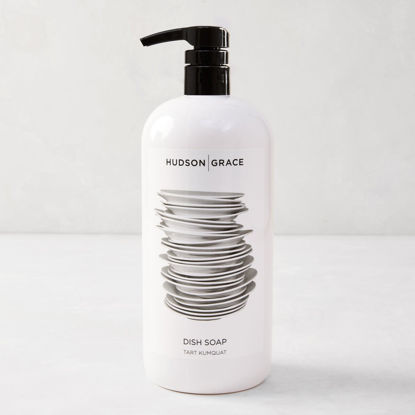 White HG Tart Kumquat Dish Soap bottle with a black pump, featuring a stack of plates design.