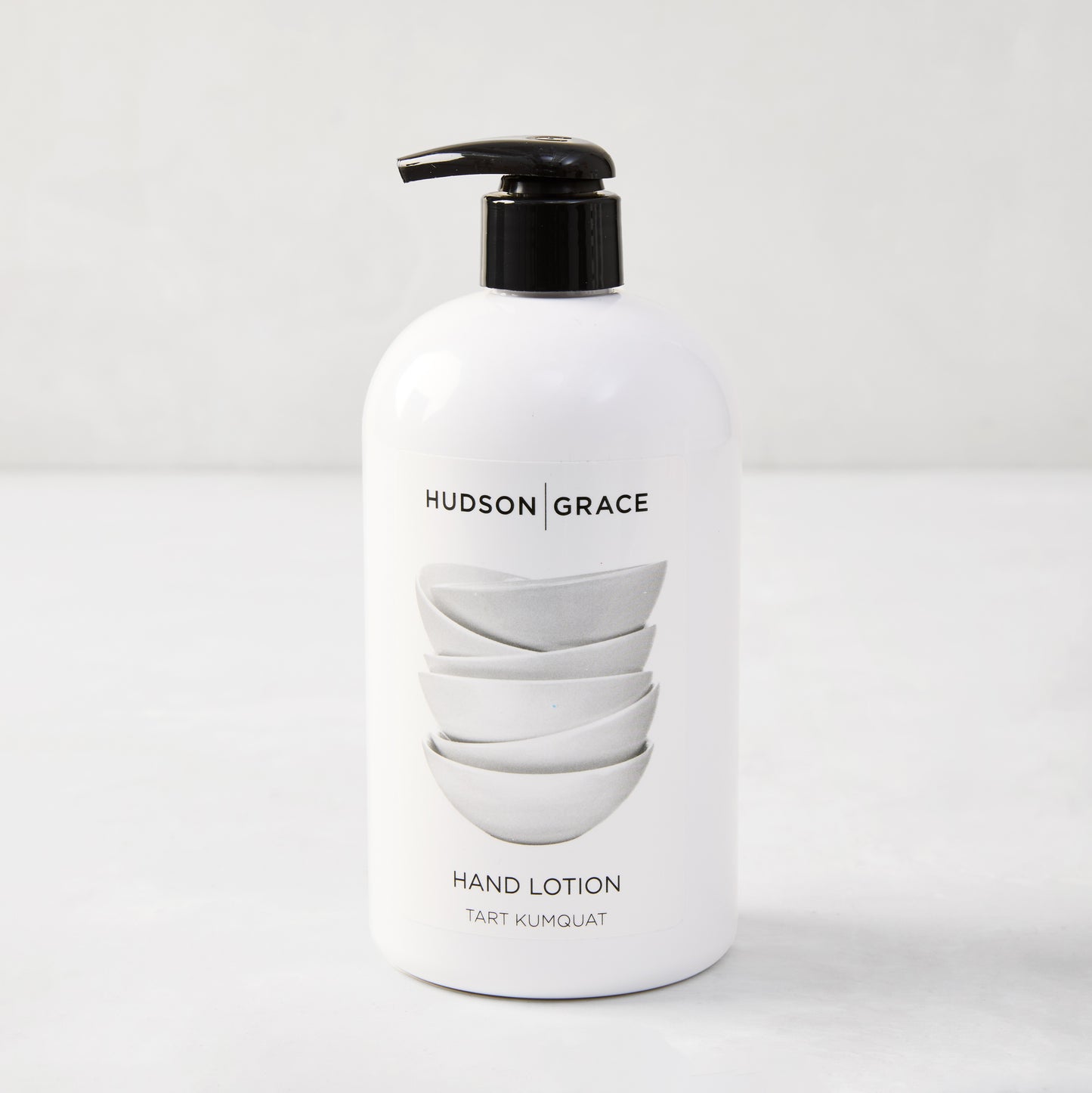 White HG Tart Kumquat Hand Lotion, 16 oz, with black pump and stacked bowls design.