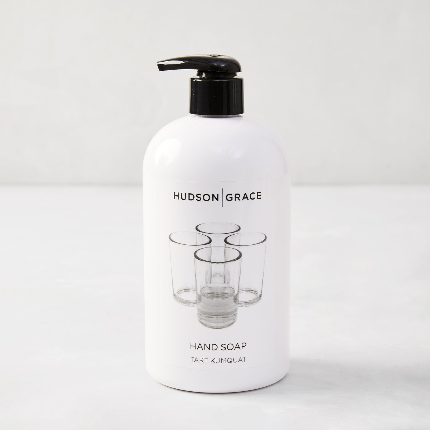 Hudson Grace Tart Kumquat Hand Soap, 16 oz, white bottle with black pump and glass graphic.