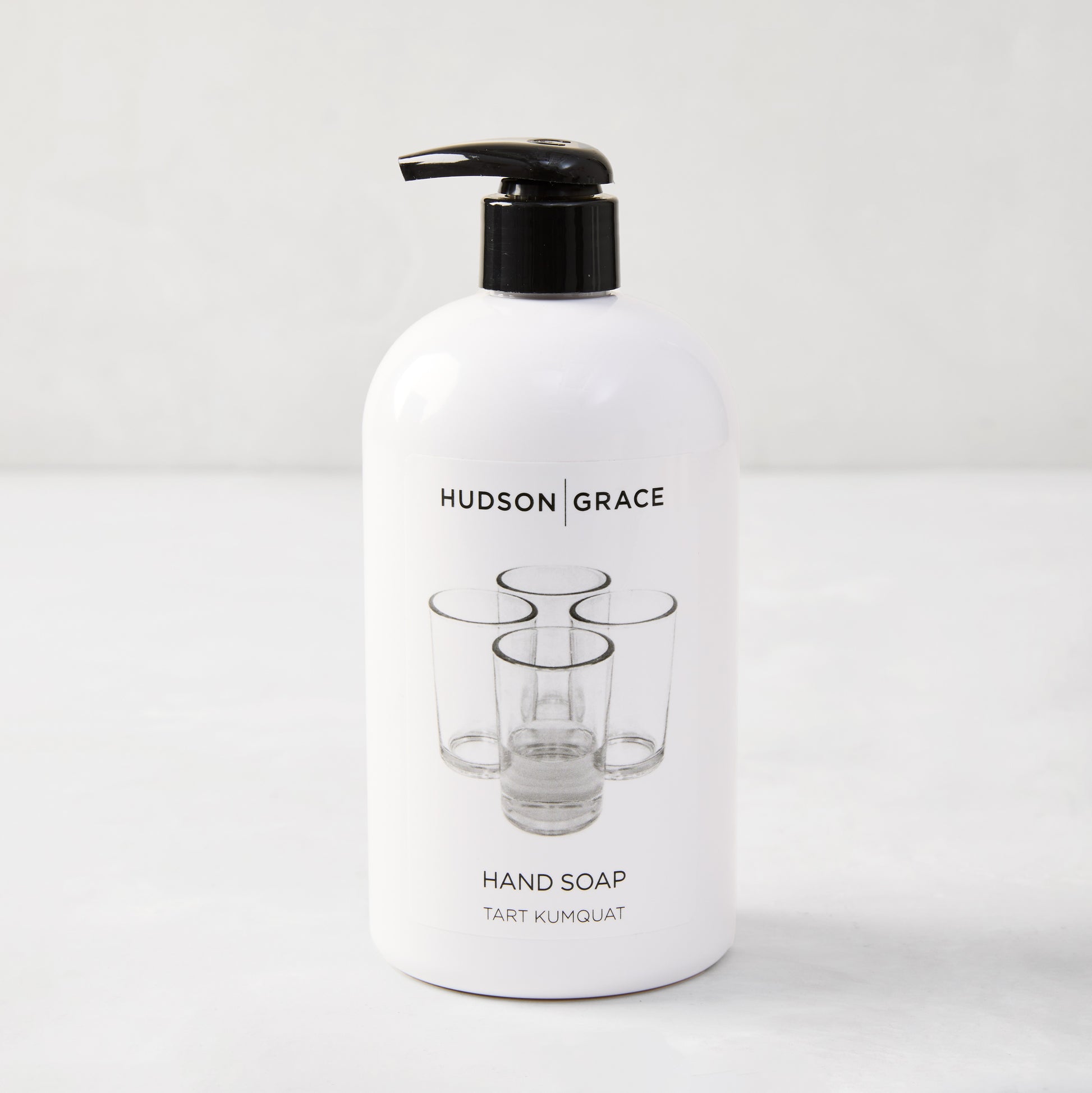Hudson Grace Tart Kumquat Hand Soap, 16 oz, white bottle with black pump and glass graphic.