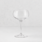 Clear glass Tavola coupe with a wide, shallow bowl and a slender stem on a white background.