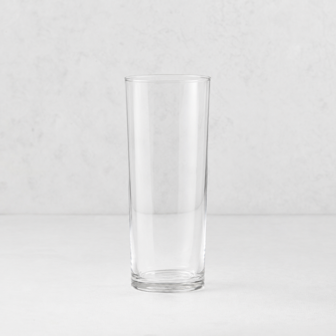 Tavola highball glass with a clear, cylindrical design and a sturdy base on a neutral background.