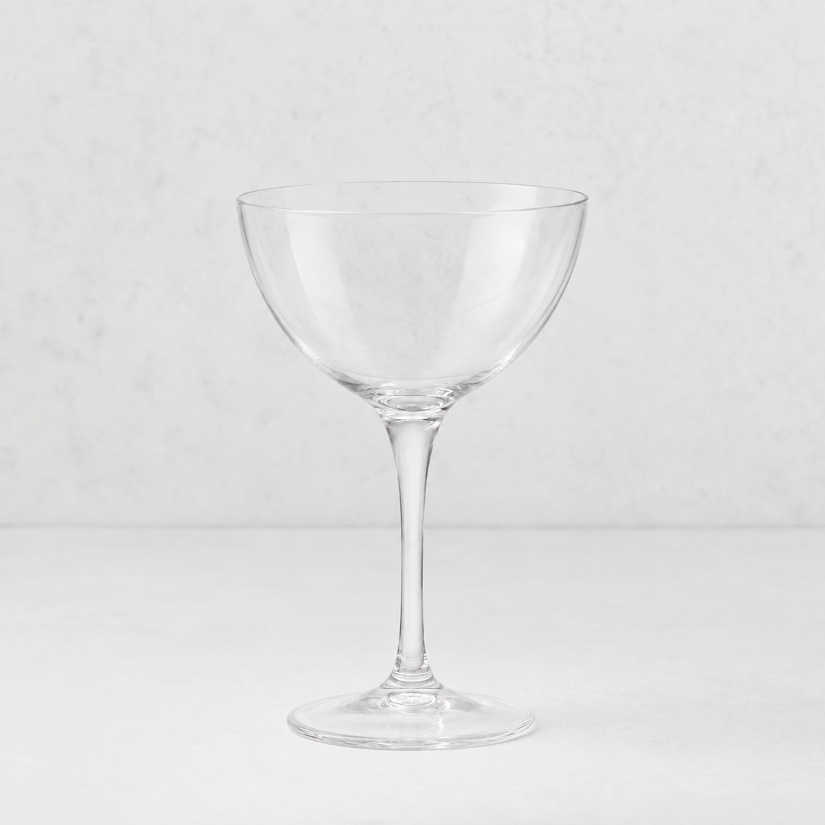 Clear glass Tavola martini coupe with a wide bowl and slender stem on a white background.