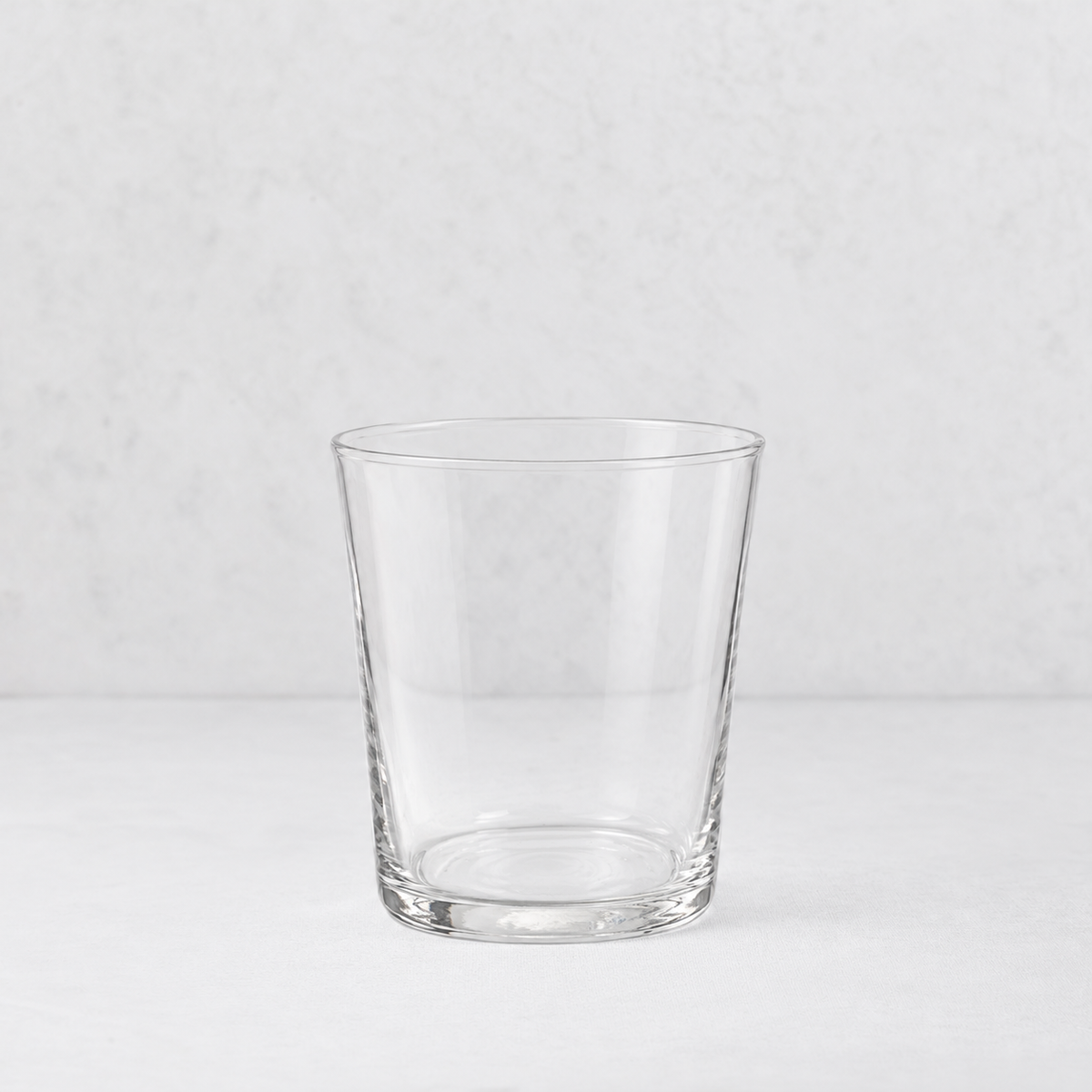 Medium Tavola tumbler made of clear, minimalist glass with a simple, tapered cylindrical design.