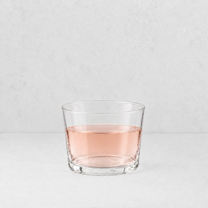 Mini Tavola tumbler in clear glass filled with a light pink liquid, set against a neutral white background.