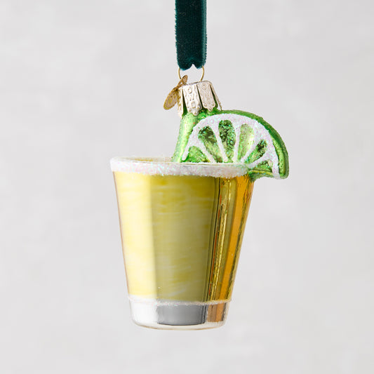 Mouth-blown glass tequila shot ornament with a gold glass, white glitter rim, and green lime slice.