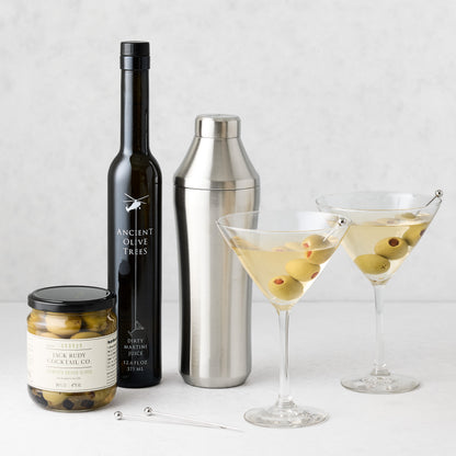 Classic Martini Gift Set with two filled martini glasses, shaker, olive jar, dirty martini juice bottle, and picks.