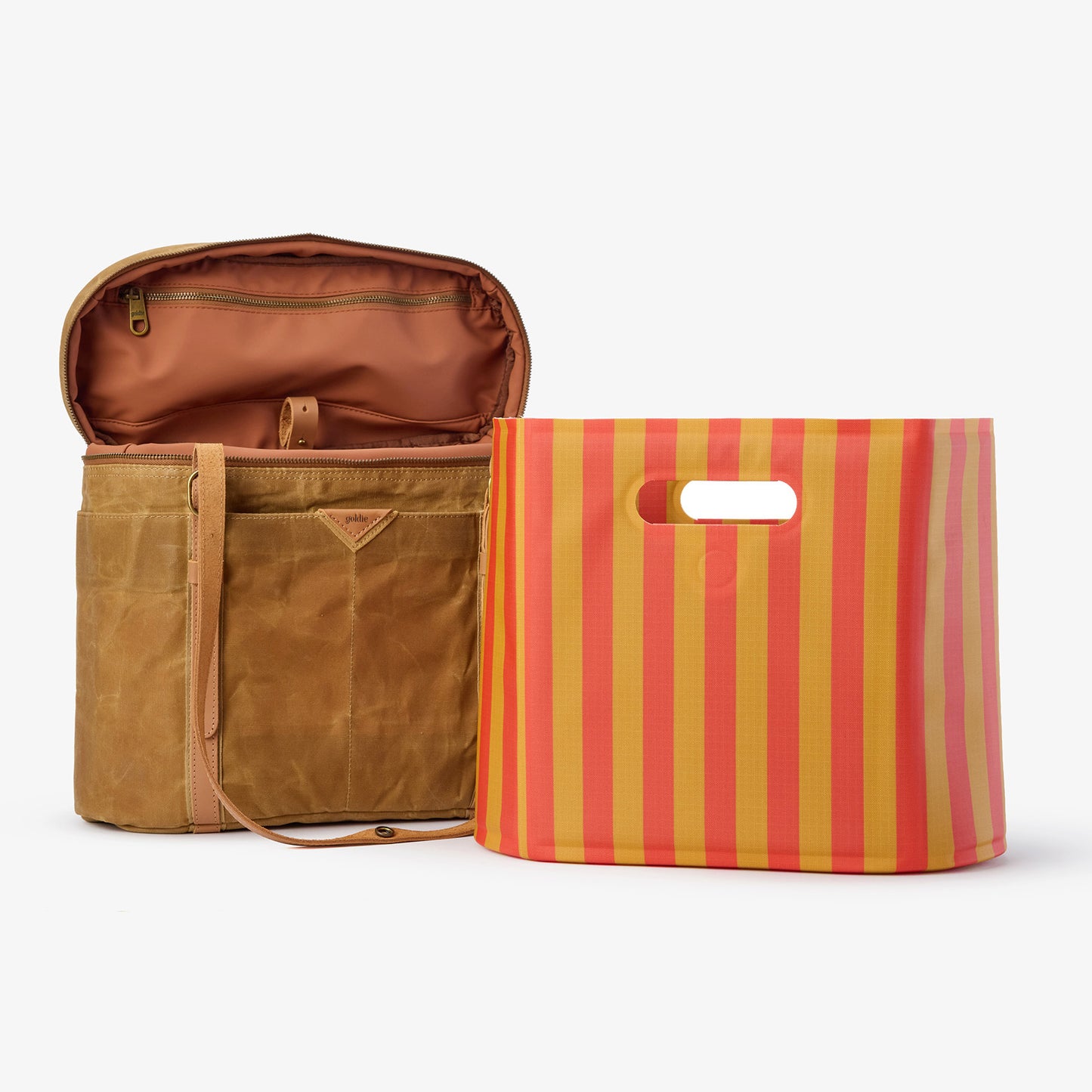 Open Goldie Picnic Bag in brown waxed canvas next to a red and gold striped Picnic Stripe tote.