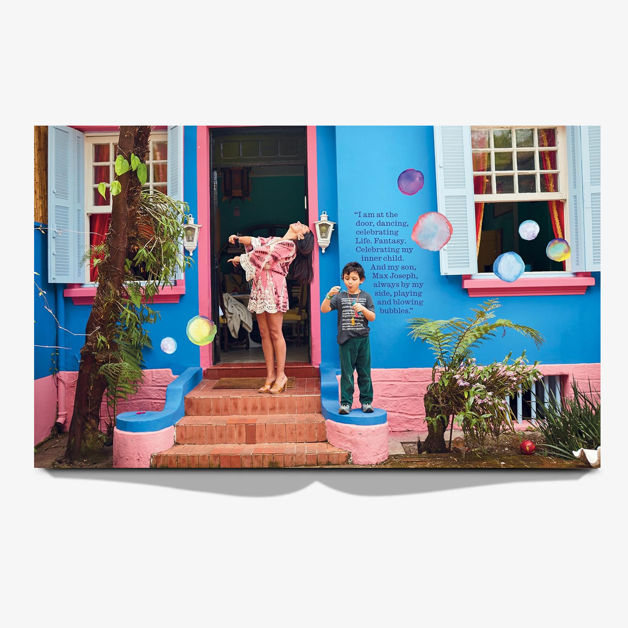 Open book spread featuring a vibrant blue house with pink trim, a woman posing, and a boy blowing bubbles.