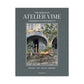Hardcover book, "The World of Atelier Vime," gray linen cover with a courtyard scene.