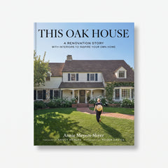 Hardcover coffee table book featuring a woman walking toward a historic white house with a brick path and green lawn.