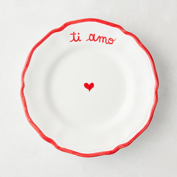 White ceramic appetizer plate with red "ti amo" text, heart, and ruffled border.