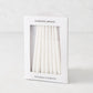 Box of 45 slender, white hand-dipped paraffin taper candles for a Hanukkah Menorah by Hudson Grace.