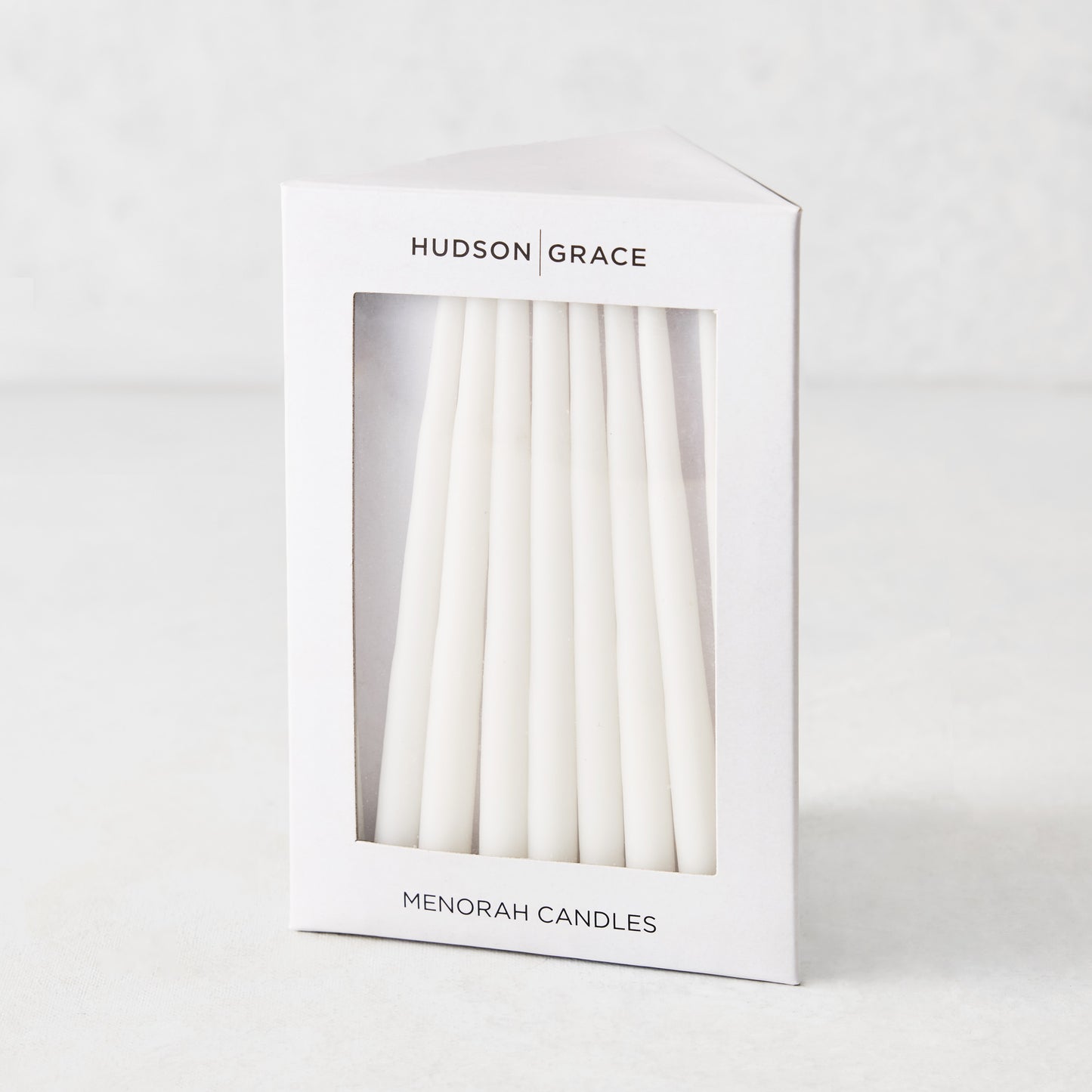 Box of 45 slender, white hand-dipped paraffin taper candles for a Hanukkah Menorah by Hudson Grace.