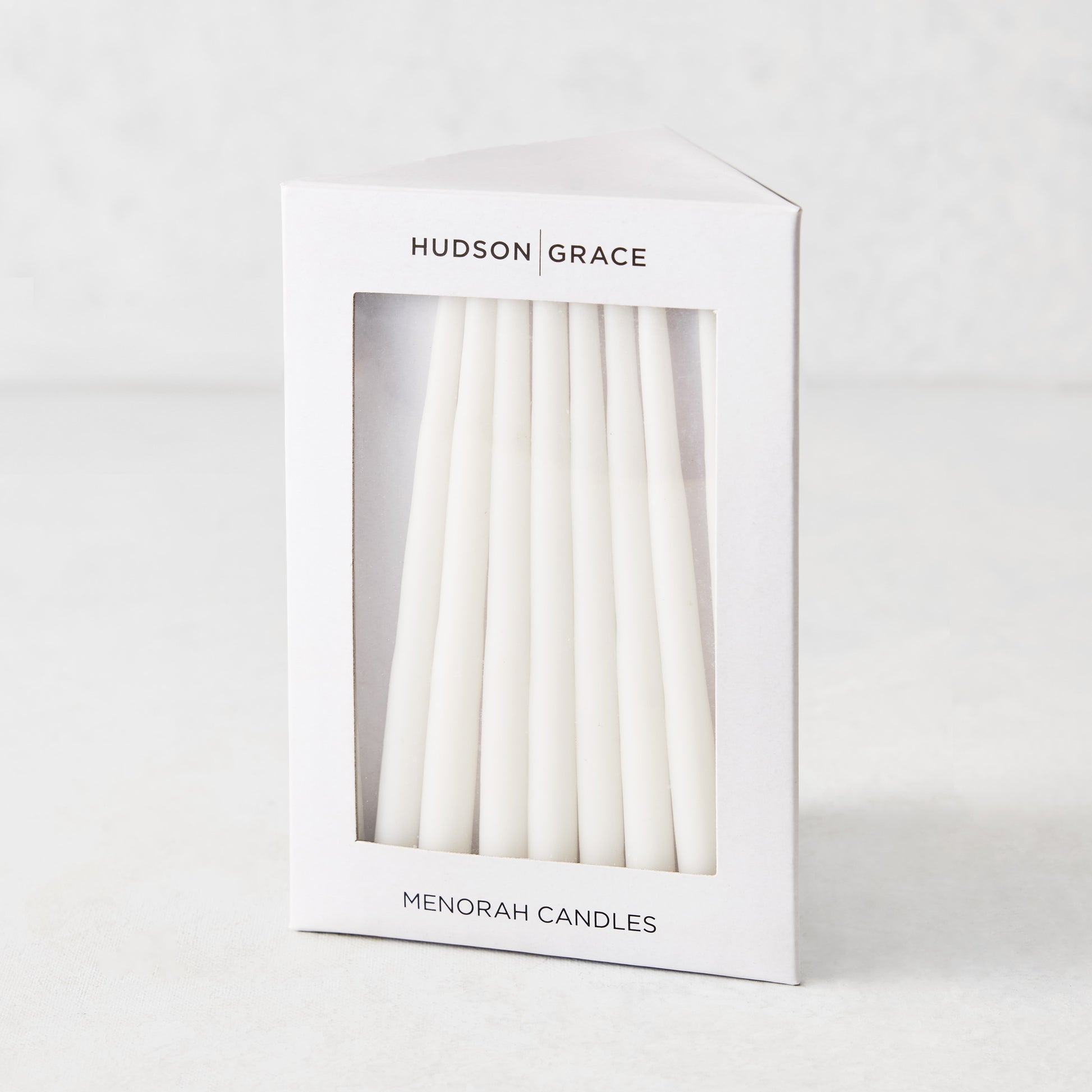 Box of 45 slender, white hand-dipped paraffin taper candles for a Hanukkah Menorah by Hudson Grace.