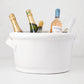 Tivoli white ceramic ice bucket with two handles, holding multiple bottles of wine and champagne.