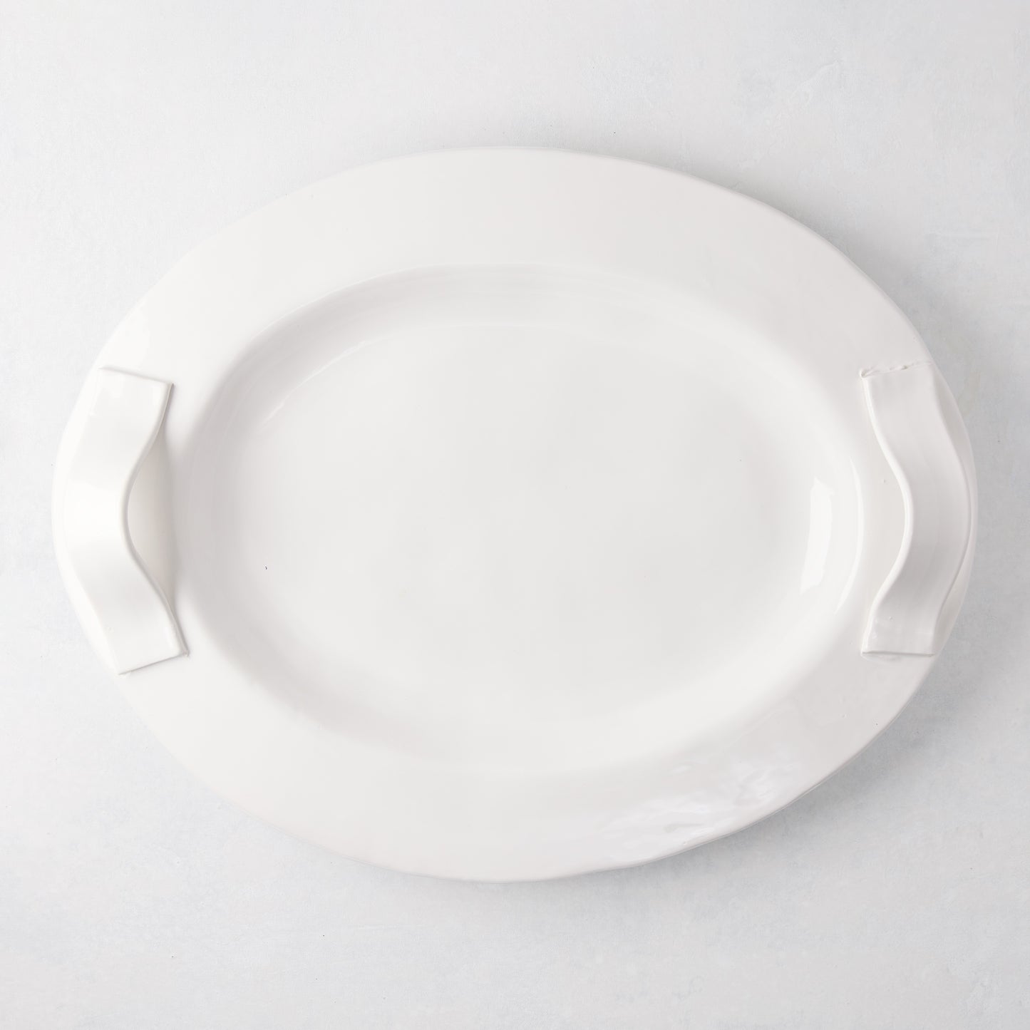 Tivoli white ceramic oval serving platter with two elegant handles.