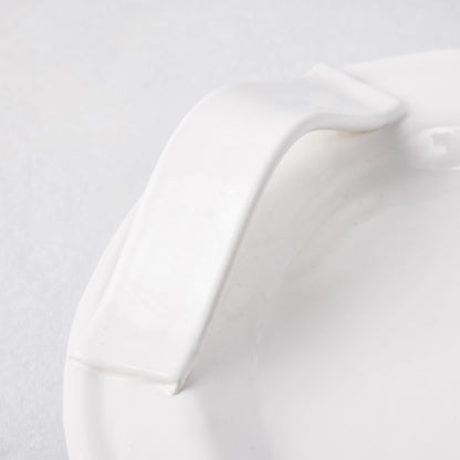 Close-up of a white ceramic handle on the Tivoli oversized long serving platter.