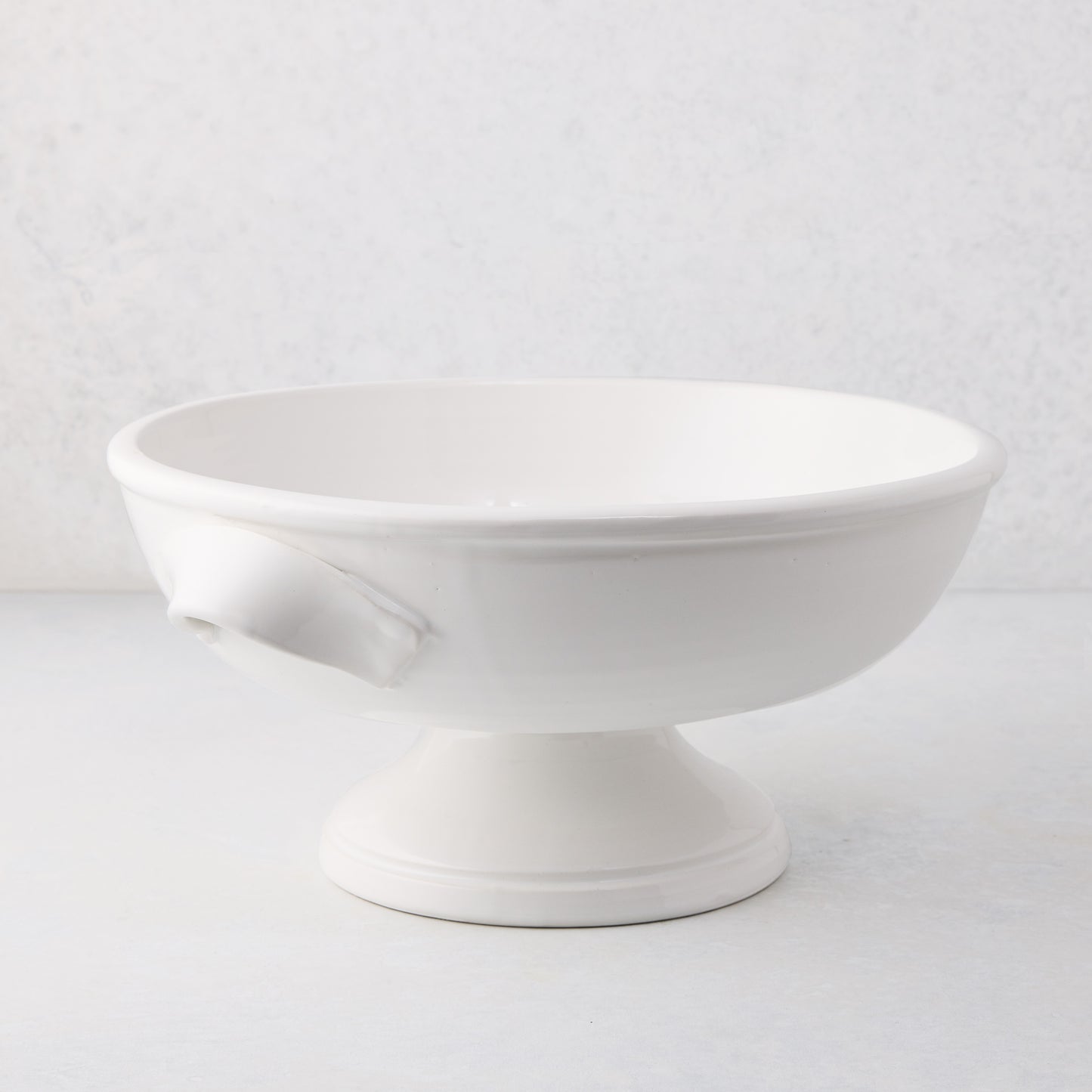 Tivoli white ceramic pedestal serve bowl with two handles, 15.3"L x 13.3"W x 6.7"H.