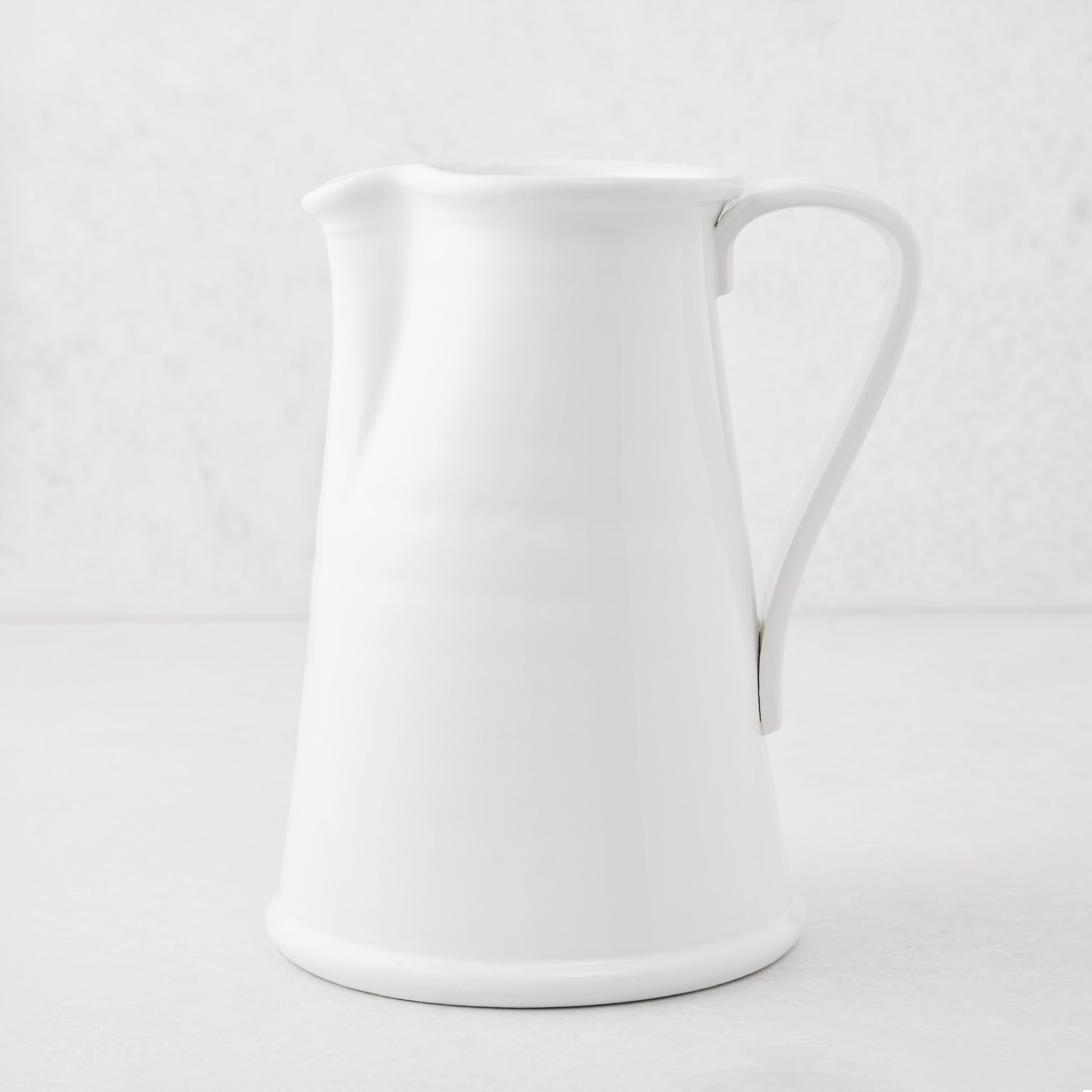 Tivoli white ceramic pitcher with a simple flat handle, 8.6"H.