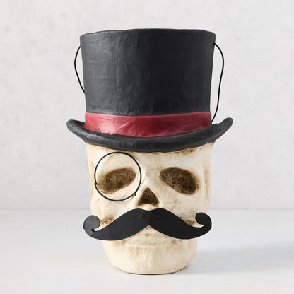 11-inch papier-mâché skull candy bucket wearing a black top hat with red band, a monocle, and a black mustache.