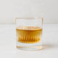 Tratto Ribbed Eco-Crystal Old Fashioned Glass with amber liquid and ice.